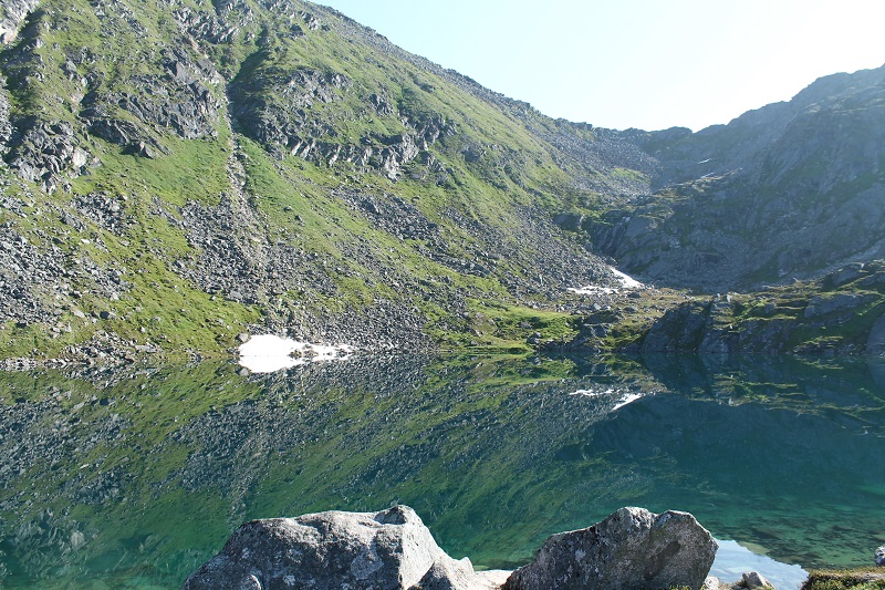 Priezračná hladina jazera Gold Cord na ktorej sa odrážajú okolité kopce