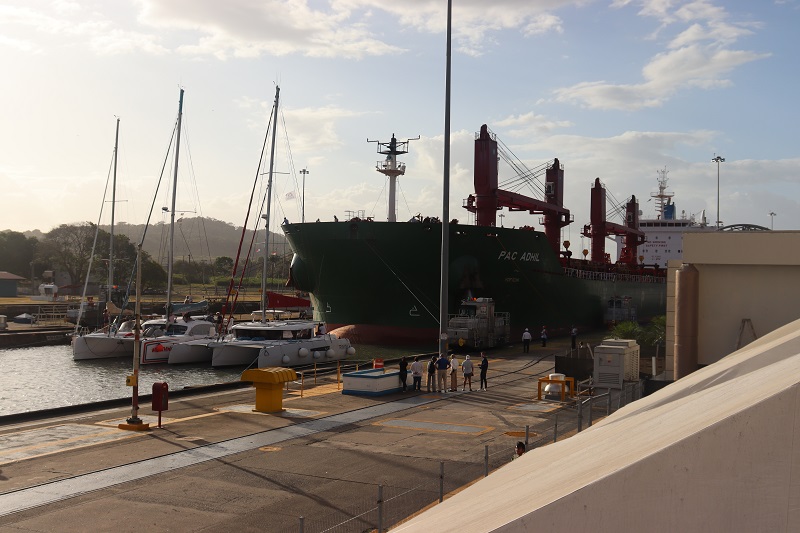 Plachetnice a ďalšia veľká loď plávajúca cez Panamský prieplav